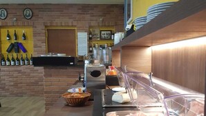 A buffet setup with a variety of meats, a selection of cheeses, and a wine display. - CASA CASTELLA (Diano d'Alba)
