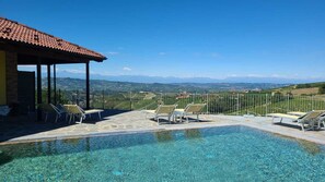 Una piscina al aire libre de temporada, sombrillas