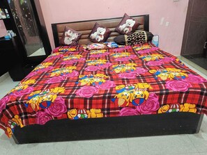 Cozy bedroom with a vibrant bedspread, two pillows, and a dark headboard.