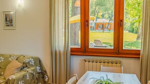 A room with a view of an outdoor area, a radiator, a table, and a floral-patterned sofa. - Residence Casa Adriana (Costermano sul Garda)