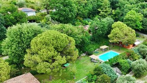 A residential area with a swimming pool, surrounded by dense greenery and trees. - Residence Casa Adriana (Costermano sul Garda)