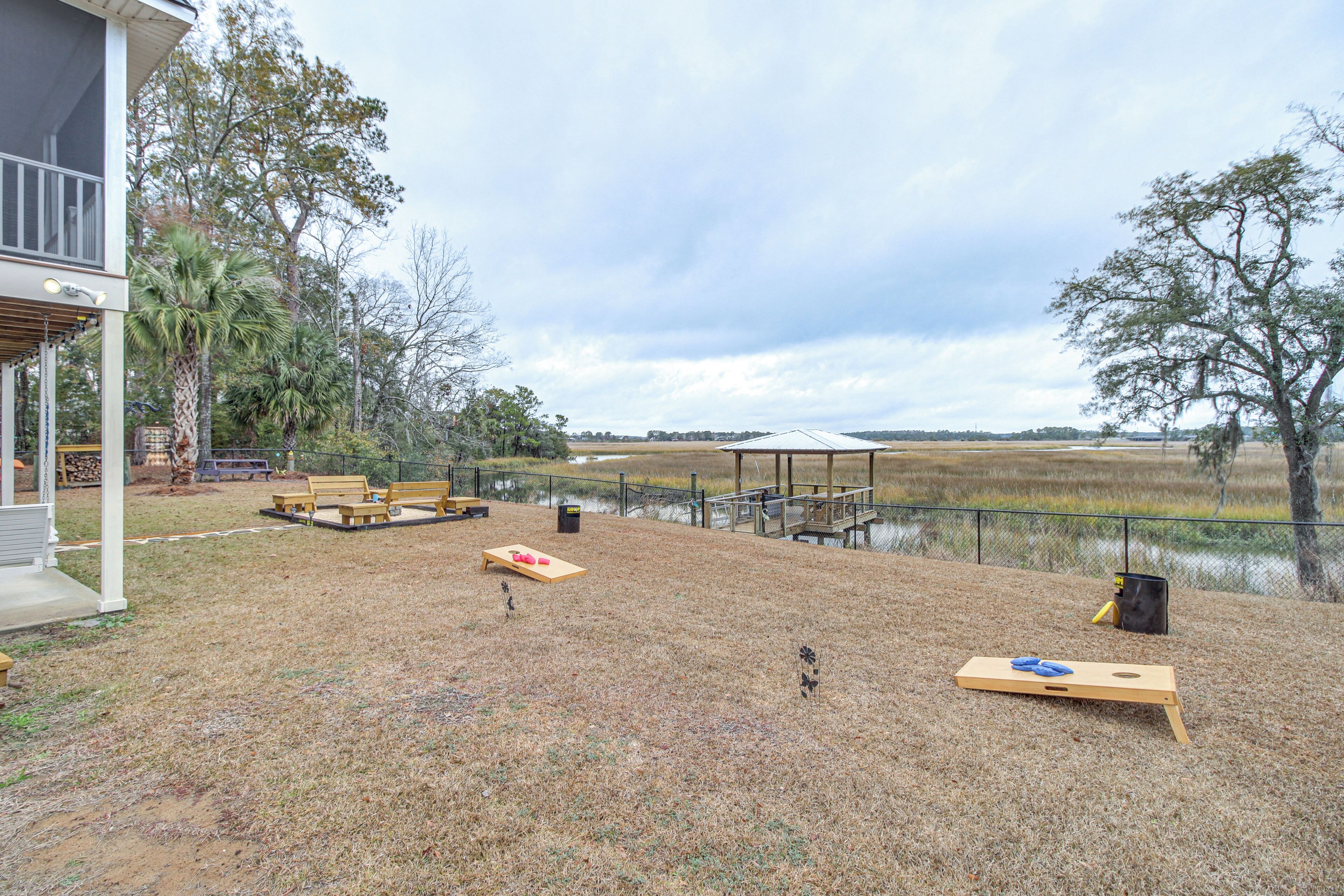 An outdoor patio area with wooden benches, a covered seating area, and a view of a water body.