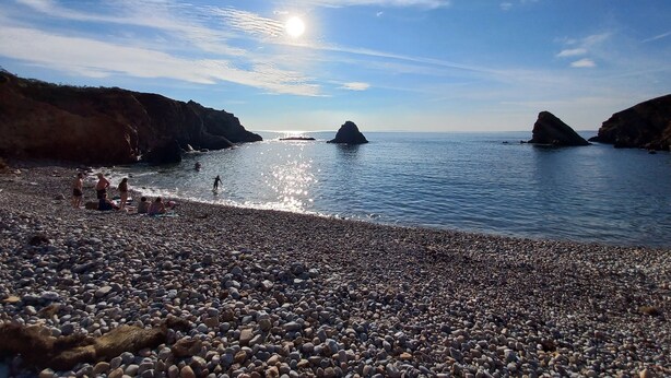 A pebbled beach with rocky cliffs and calm sea. - Home. Pointe des Espagnols. (Roscanvel)