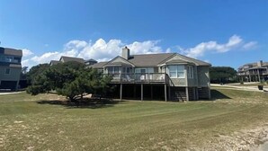 A two-story house with a covered porch and a small tree in front. - Shabedge, Ships Watch Community in Duck, NC (Kitty Hawk)