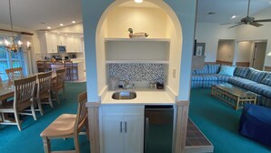 A compact living space with a kitchenette, dining area, and seating area. - Shabedge, Ships Watch Community in Duck, NC (Kitty Hawk)