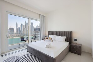 Relax in a spacious room with a large bed, bedside table, and balcony offering a city view.