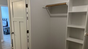 A closet with a door, a shelf, and a white wall. - 2BR The Bandit Suite (Lexington)