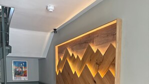 Ein Flur mit einem Holzbild, einem gerahmten Bild und einer Treppe.