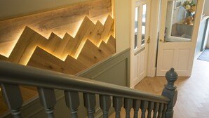 Eine Treppe mit Wandverkleidung aus Holz und einer Tür mit der Aufschrift "Frühstücksraum".