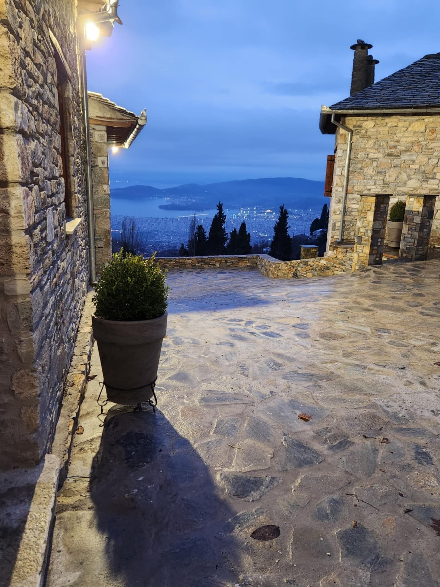 A stone pathway leading to a view of a cityscape and water.