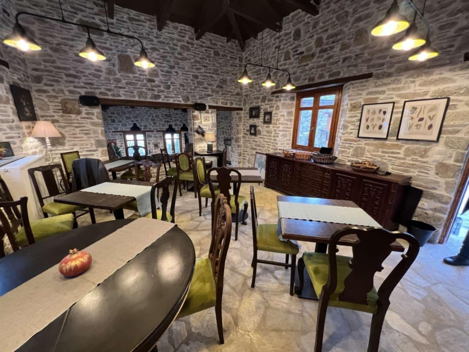 Un comedor rústico con paredes de piedra, muebles de madera e iluminación colgante.