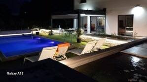 A modern house with a swimming pool, outdoor seating, and a well-lit patio area. - 4CH villa with pergola, swimming pool located 4km from Lac CARCANS and 9km from the Ocean (Carcans)