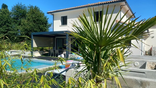 A modern house with a swimming pool, outdoor seating, and a covered patio area. - 4CH villa with pergola, swimming pool located 4km from Lac CARCANS and 9km from the Ocean (Carcans)
