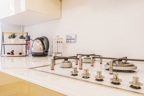 Kylskåp, spishäll, kaffe- och tebryggare och grytor/köksredskap