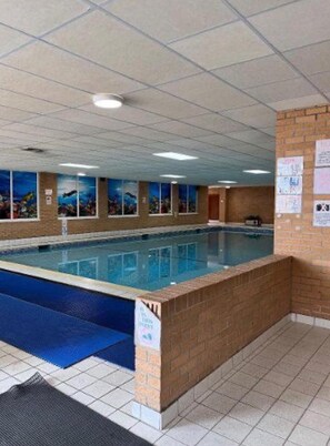 An indoor swimming pool with a tiled floor and walls, a blue mat at the pool's edge, and a ceiling with recessed lighting. - 2 Bed Caravan With Aberystwyth Town Viev (Aberystwyth)