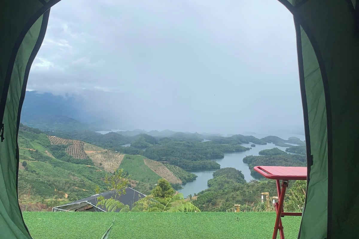Une tente offrant une vue sur un paysage verdoyant et un plan d’eau.