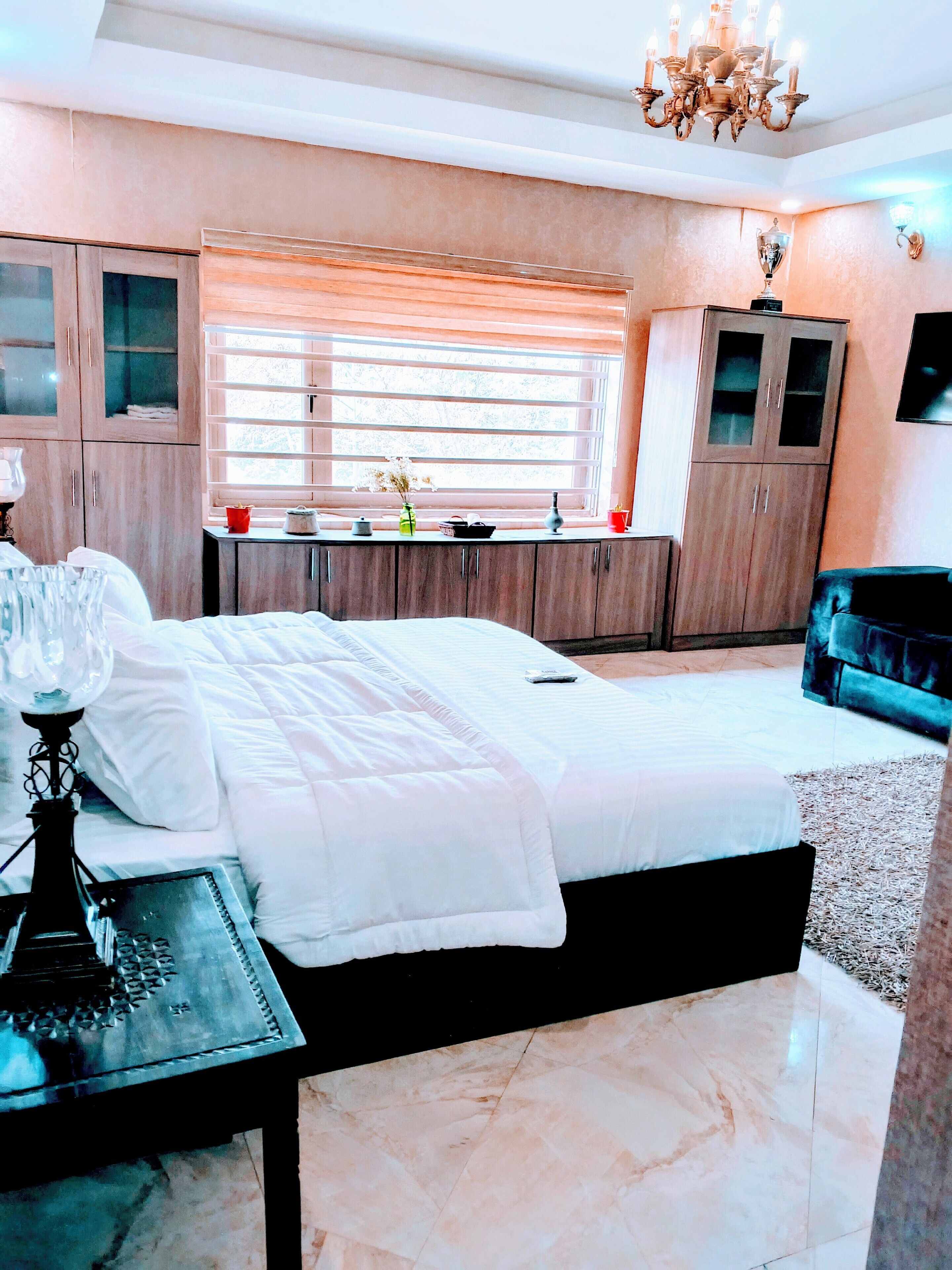 A bedroom with a bed, a desk, a chair, and a wardrobe.