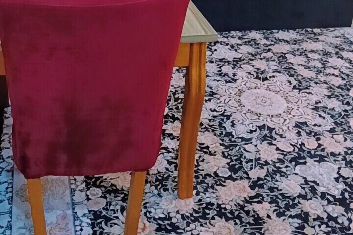 Une chambre d’hôtel avec un lit, une table à manger avec des chaises et un tapis à motifs.