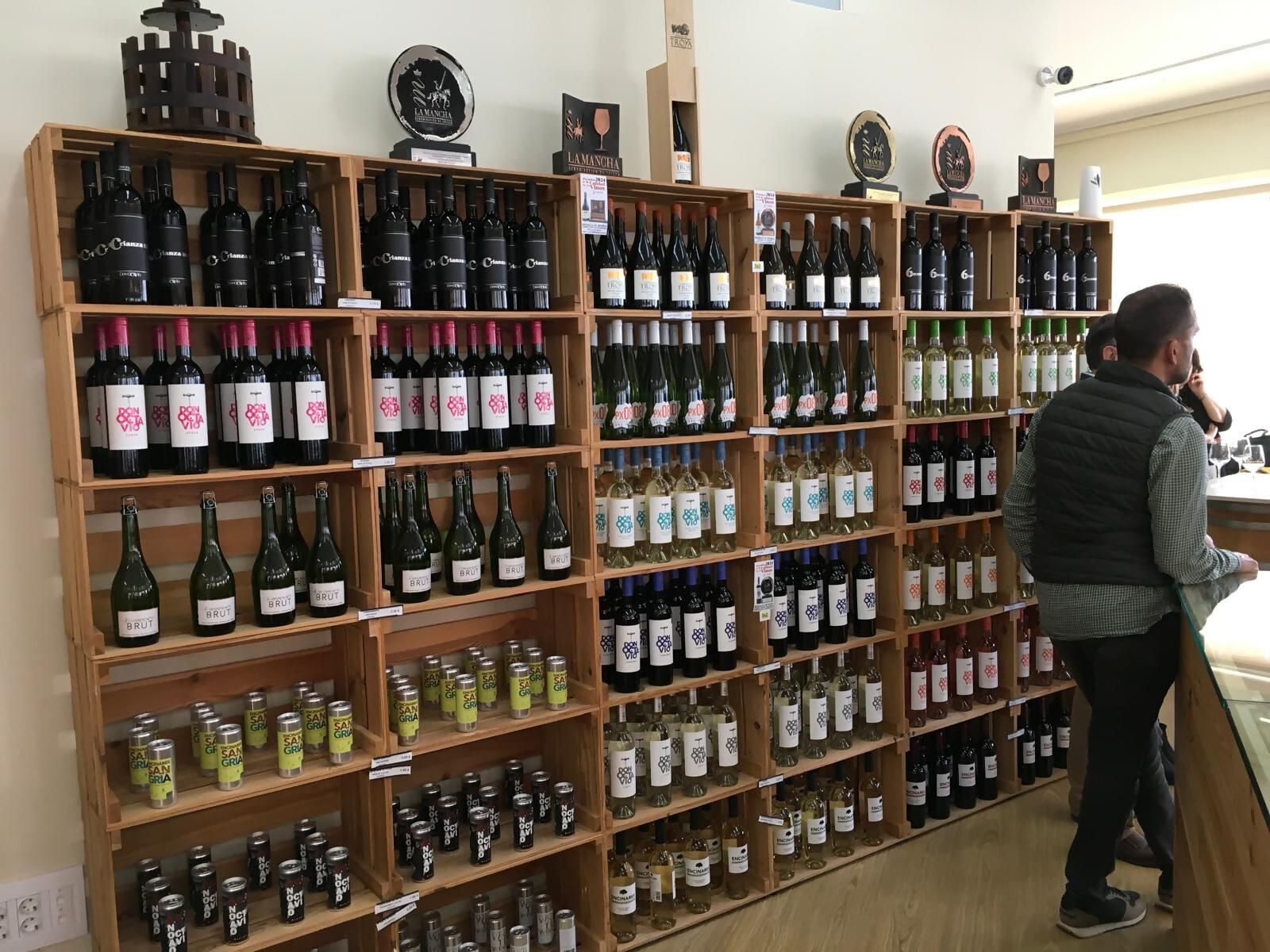 Une cave à vin où les étagères sont remplies de différentes bouteilles et canettes de vin.