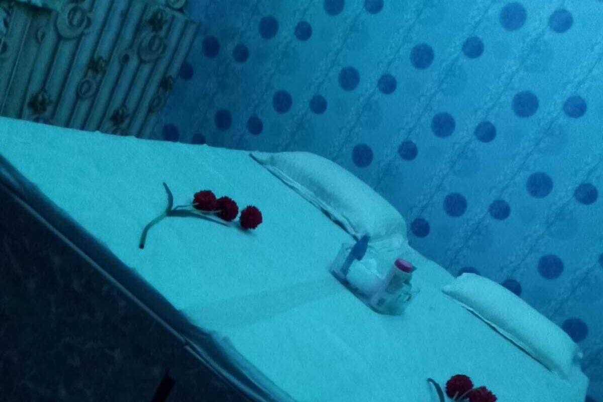 A room with a bed, a telephone, and a bottle of water.
