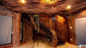 A wooden interior with a spiral staircase and a hanging plant.