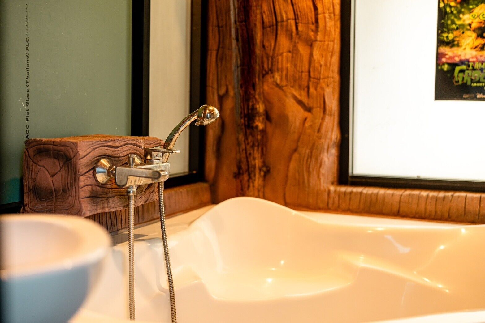 Un baño con tocador de madera, una bañera blanca y un cabezal de ducha.