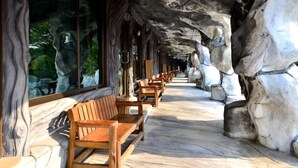 A corridor with wooden benches and stone walls.