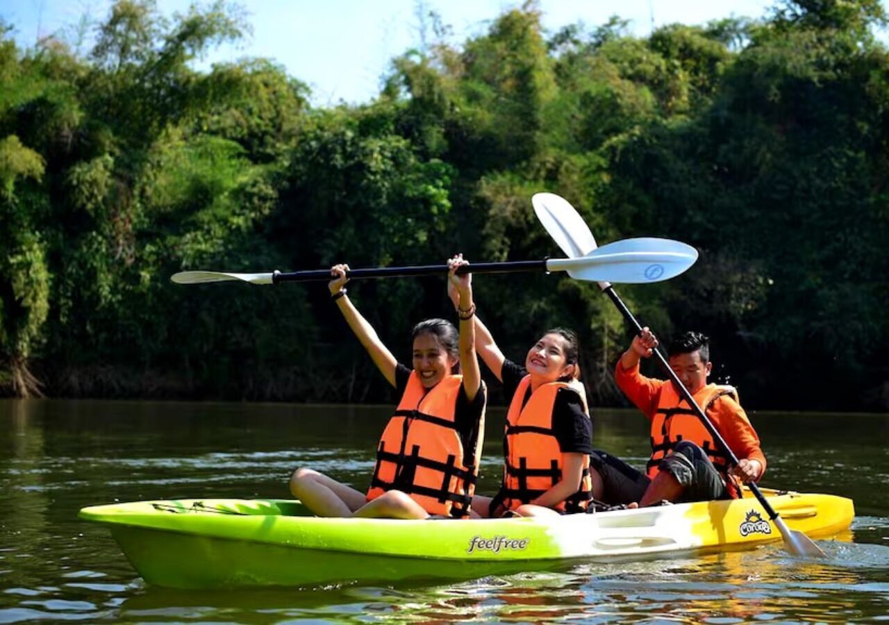 Three people in a kayak on a river.