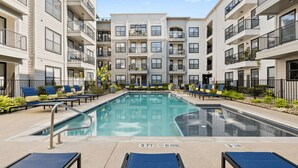 A modern apartment building with a central swimming pool, lounge chairs, and a no diving sign. - Chic 1BR Retreat | Walk to SoCo, Pool & Wi-Fi (Austin)