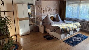 A bedroom with a bed, a wardrobe, a window, and a plant. - Cozy - Guest room (Notzingen)