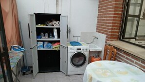 Uma lavanderia compacta com máquina de lavar, varal e uma pia pequena.