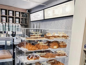 A bakery display with various pastries and a coffee shop menu.