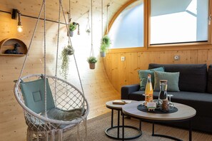 A cozy room with a hanging chair, a sofa, a small table with drinks, and plants. - Cocci-vert à L'oasis des Coccinelles (Sainte-Croix-aux-Mines)