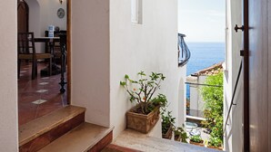 Una stretta scala conduce a un balcone con vista sulla costa.