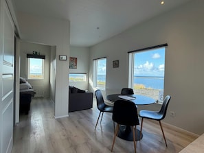 Une chambre moderne avec un coin repas, un canapé et une vue sur la mer.