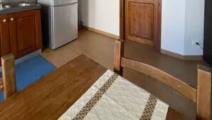 A kitchen with wooden cabinets, a stainless steel refrigerator, and a wooden door. - House with terrace near the Beach - Eden Holiday Home (Termini Imerese)