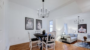 A dining area with a round table and chairs, a chandelier, and artwork on the walls. - Charming 2-bedroom, 1 bath apartment in historic Cabbagetown (Toronto)