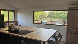 Ein Essbereich mit Holztisch, Stühlen und Blick auf einen umzäunten Außenbereich.
