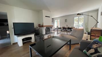 Tv, eldstad, ett bordtennisbord och böcker