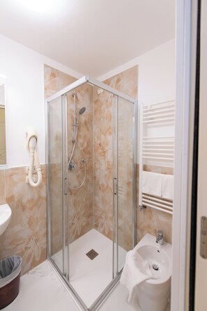 Deluxe eenpersoonskamer | Badkamer | Een douche, gratis toiletartikelen, een haardroger, handdoeken