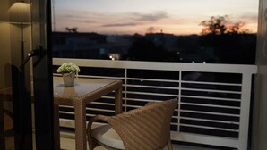 A balcony with wicker chairs and a small table with a potted plant. - Villa Isabel Hotel (Sorsogon City)