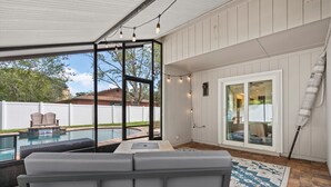 A covered outdoor area with a pool, seating, and a view of the backyard. -  Saltwater Pool I Firepits I Large Fenced Backyard I 4 Miles to Beach (Jacksonville)
