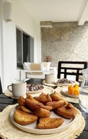 A dining table with a plate of pastries, a mug, and a glass of water.