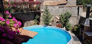 Una piscina circondata da mura in pietra e piante in vaso.