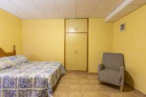 A bedroom with a bed, a wardrobe, and a chair.