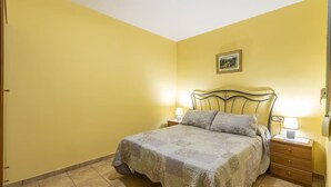 Een slaapkamer met een bed, nachtkastjes en een aan de muur hangend schilderij.