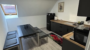 A compact kitchen with a dining area, a small window, and a ceiling light. - Vacation apartments near Legoland-Günzburg (Günzburg)
