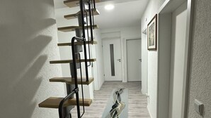 A modern staircase with a metal railing and wooden steps leading to a landing. - Vacation apartments near Legoland-Günzburg (Günzburg)