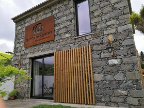 A stone building with a sign reading "QUINTA DA QUEIRO". - Quinta da Queiró (Ponta Delgada)