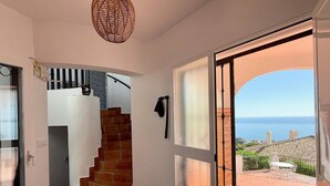 Un escalier menant à un balcon d’où l’on peut admirer la mer.